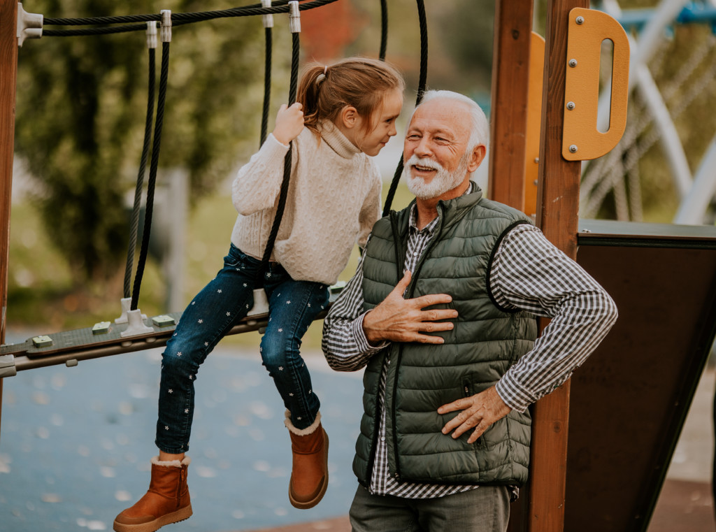 Petite fille qui s'amuse avec son grand-père